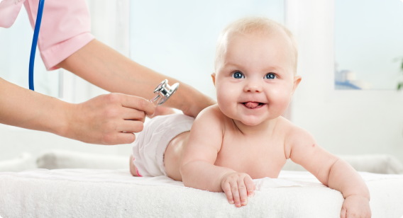 Young baby lying on a changing mat smiling